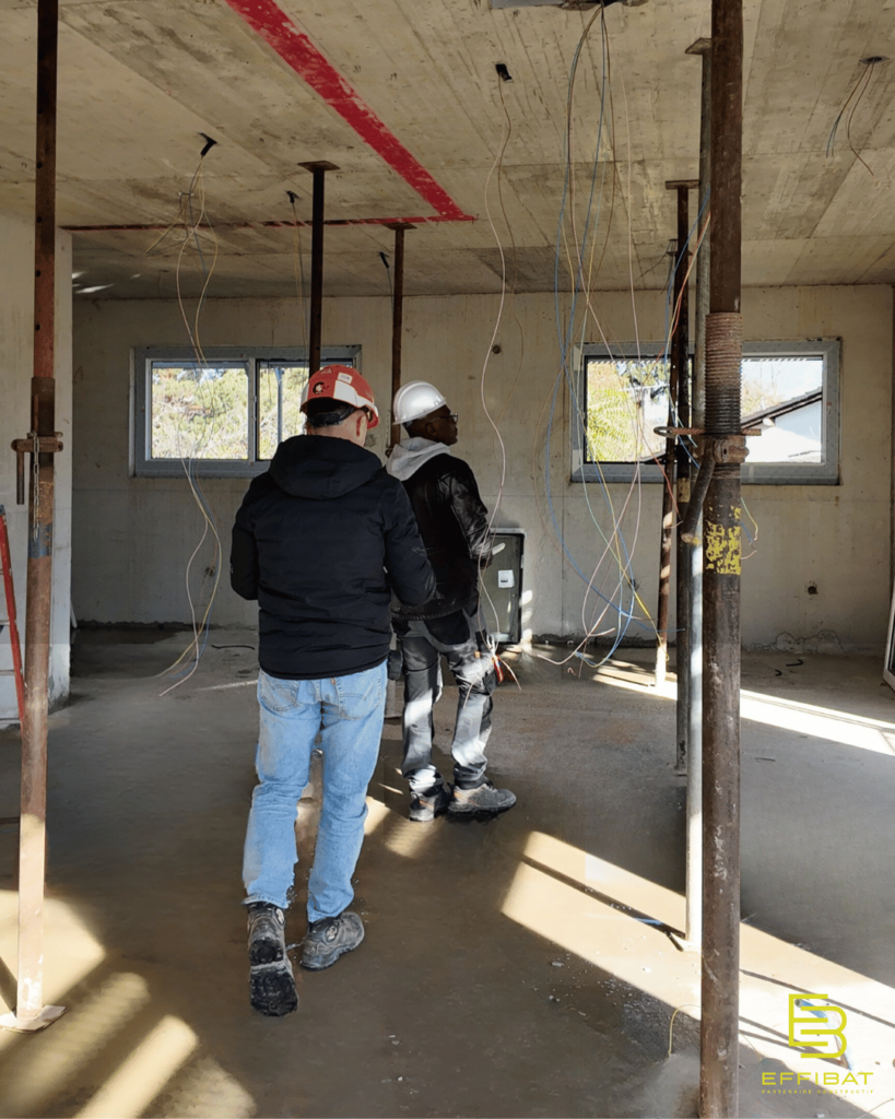 Sylvain and a colleague instaling the electricity inspect a room of one of the Jussy apartments
