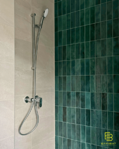 Beautiful green tiles are laid vertically in a new shower.