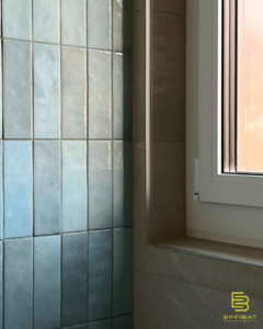 Light-blue colored tiles adorn the walls of a bathroom in this close up shot.