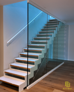 The beautiful glass staircase in Villa A, with wooden steps up to the second floor.