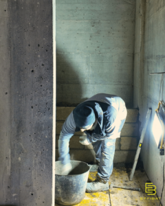 Un maçon prépare un cloisonnement pour l'installation d'une ascenseur