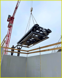 deux ouvriers controle la descente de la monte voiture