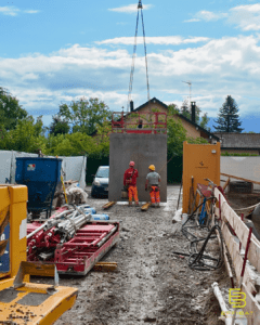 Une grue tourne et un excavateur creuse